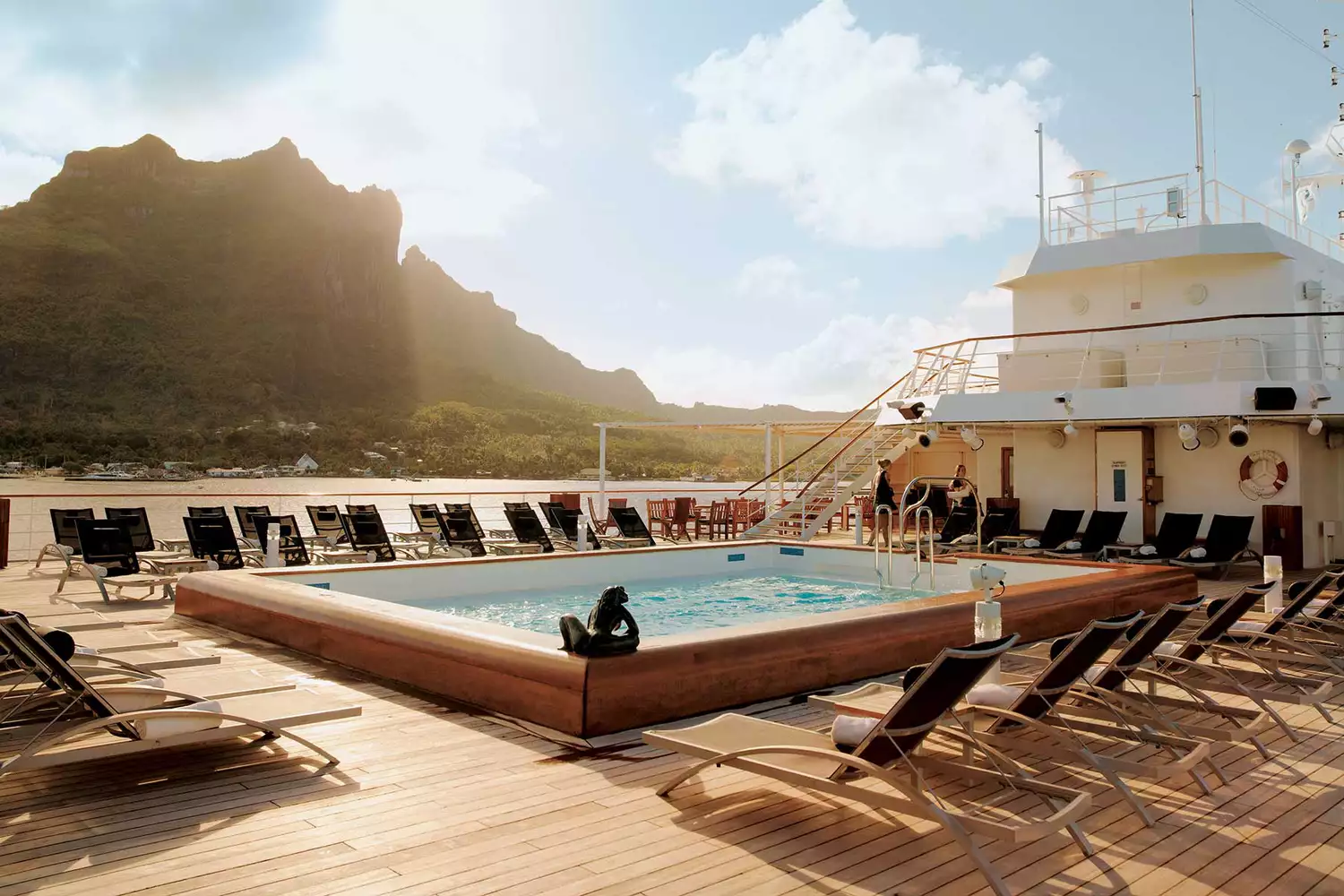 The pristine swimming pool deck on a Paul Gauguin cruise ship overlooking the ocean.