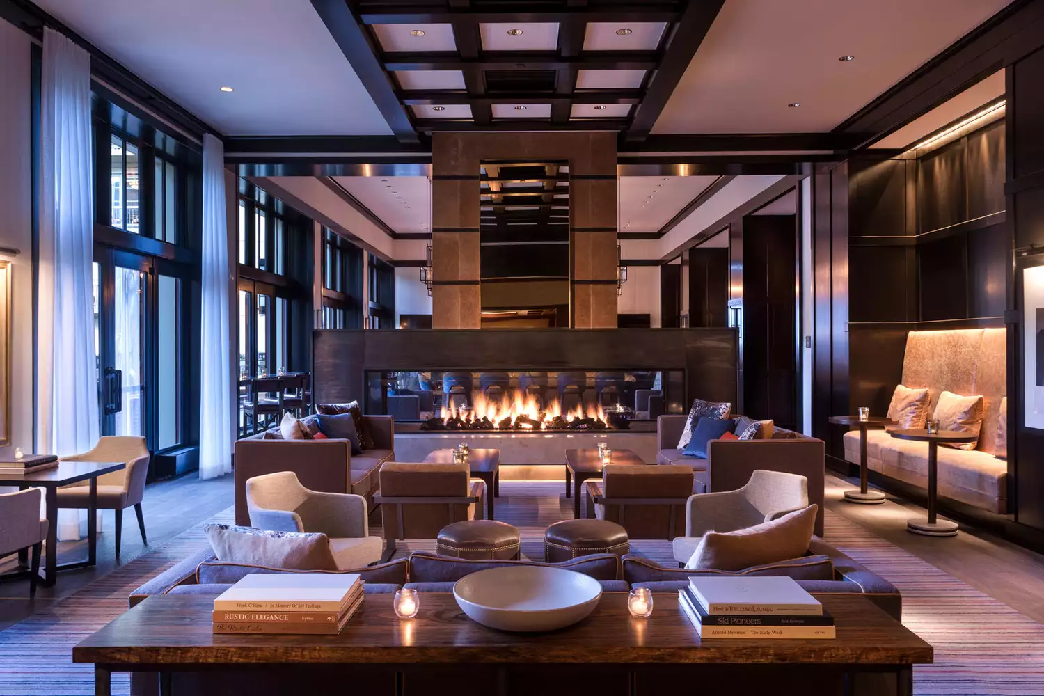 Lobby lounge at the Four Seasons Vail featuring a modern fireplace and plush seating.