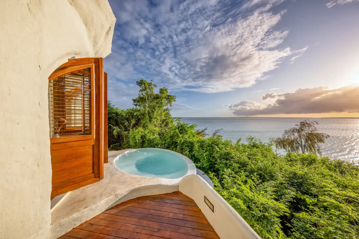 A private infinity plunge pool on a white terrace overlooking the ocean at Kilindi Zanzibar.