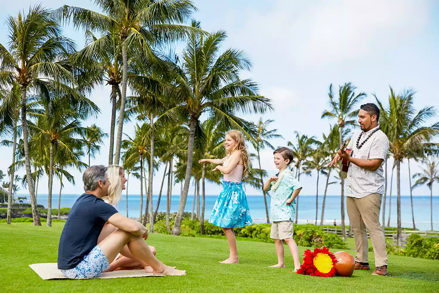 A mother and child participating in an outdoor hula lesson at Montage Kapalua Bay.