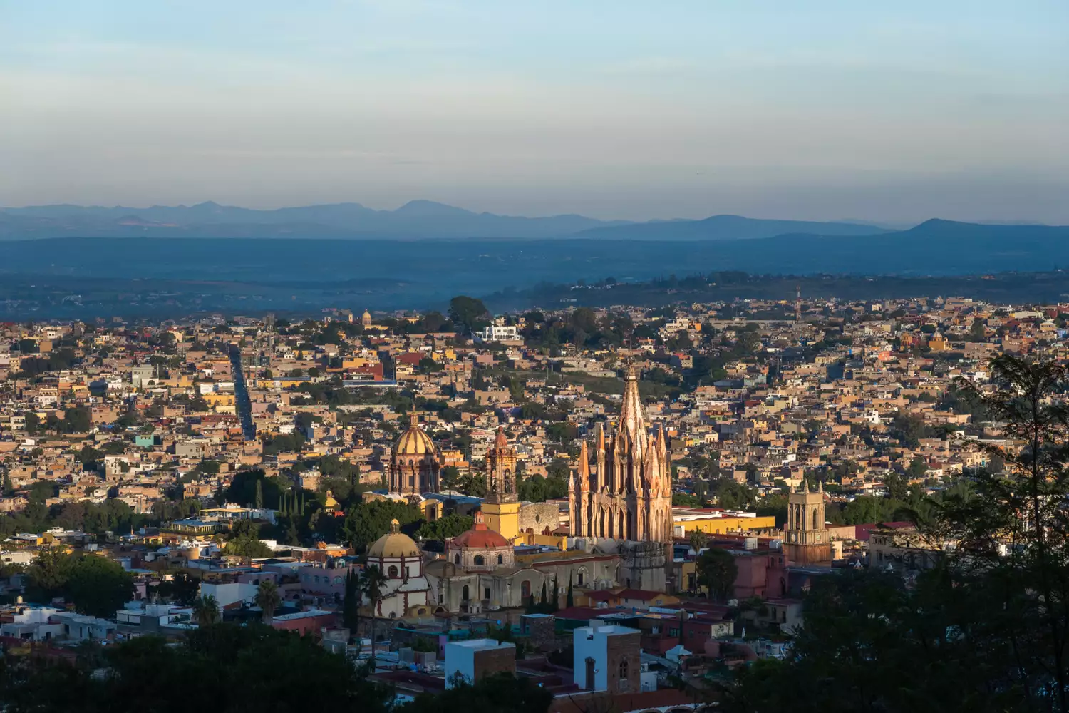 The iconic pink spires of the San Miguel de Allende cathedral seen at sunrise.
