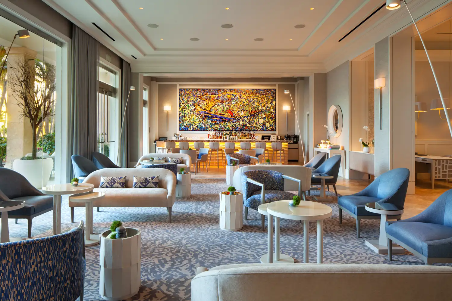 A chic hotel lounge area with contemporary furniture and a decorative wood-slat wall.