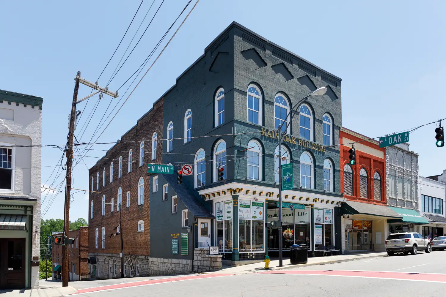 A historic brick commercial building on a corner street in downtown Mount Airy.