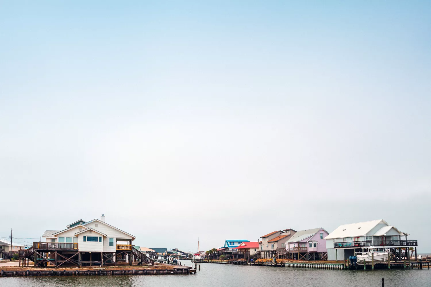 Brightly colored stilt houses along the water on Dauphin Island.