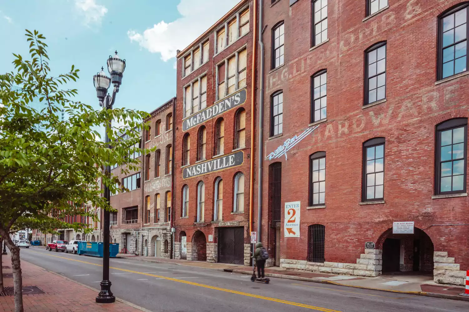 A visitor on a scooter riding past colorful historic storefronts in Nashville.