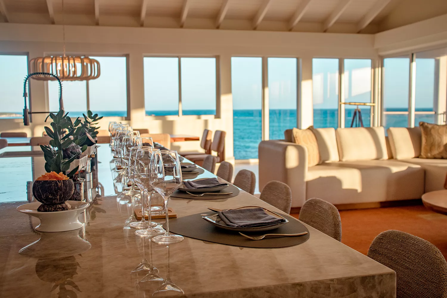 An elegantly set dining table overlooking the resort grounds at sunset.