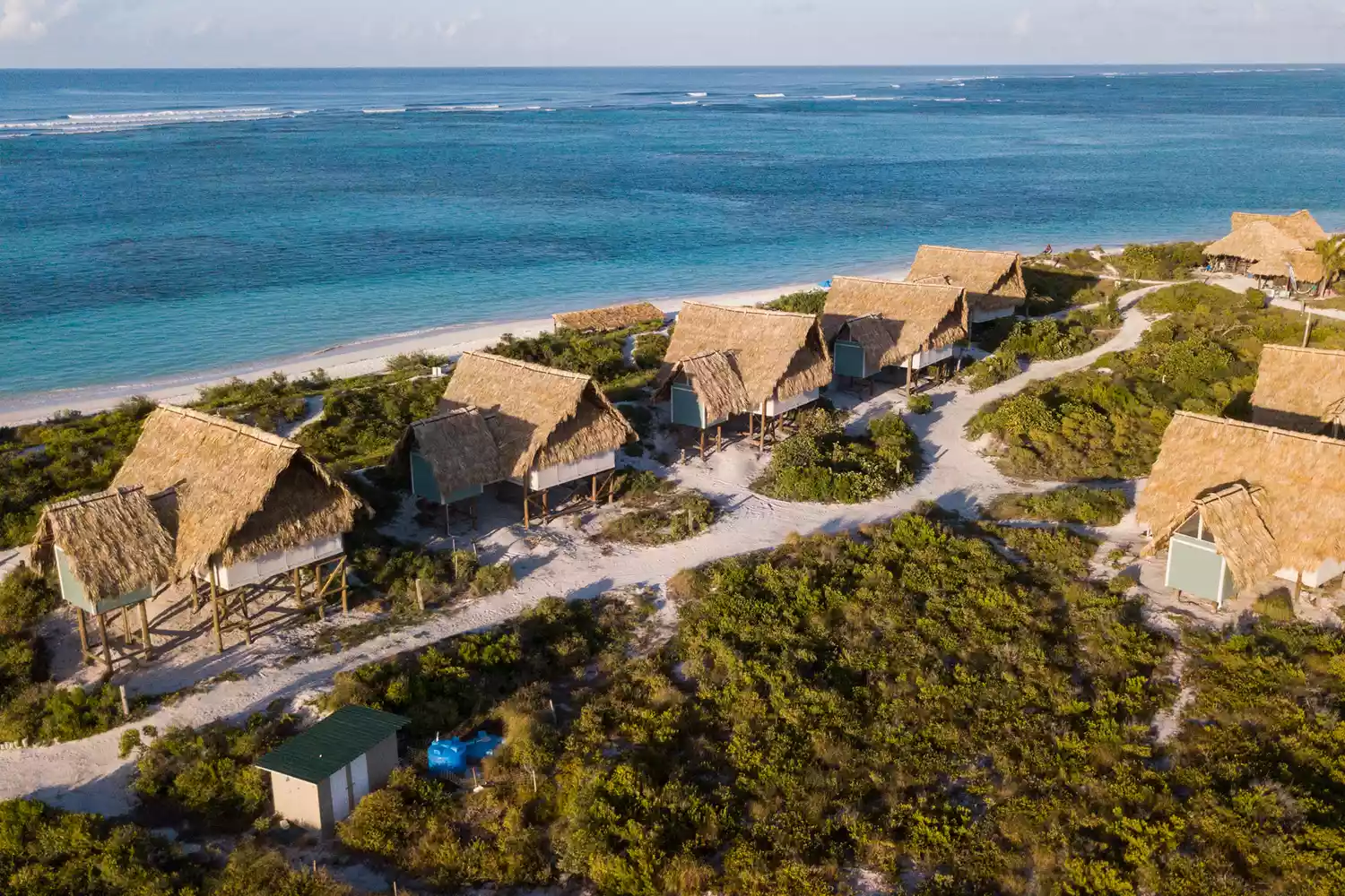 Aerial perspective of luxury beach huts and villas on the flat terrain of Anegada.