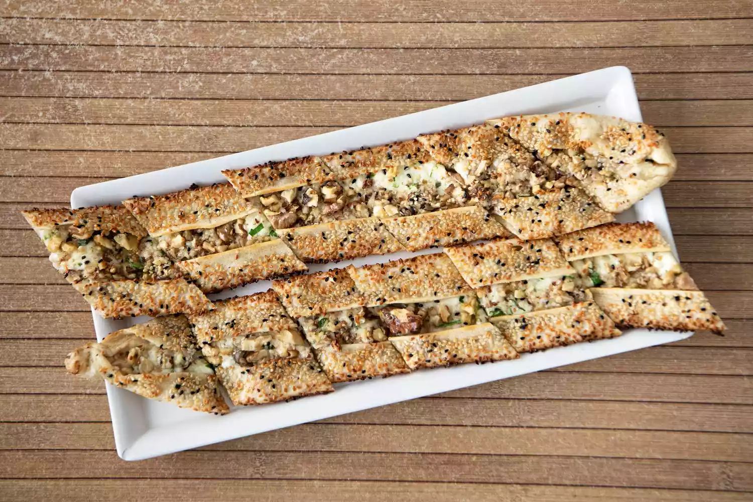 Close-up of traditional Pide flatbread stuffed with local cheese and crushed walnuts.