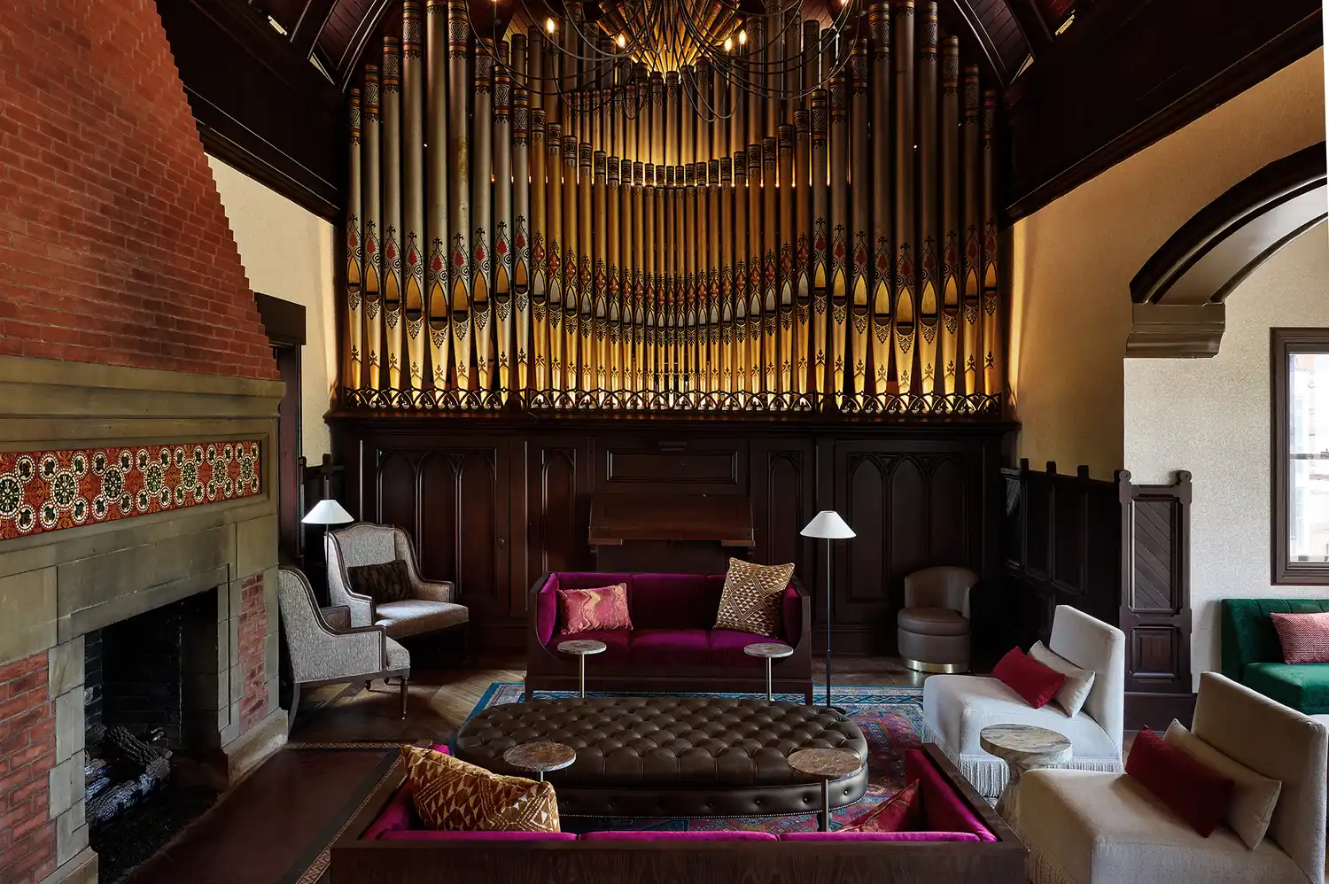 The Music Room featuring a massive 19th-century pipe organ and a warm fireplace.