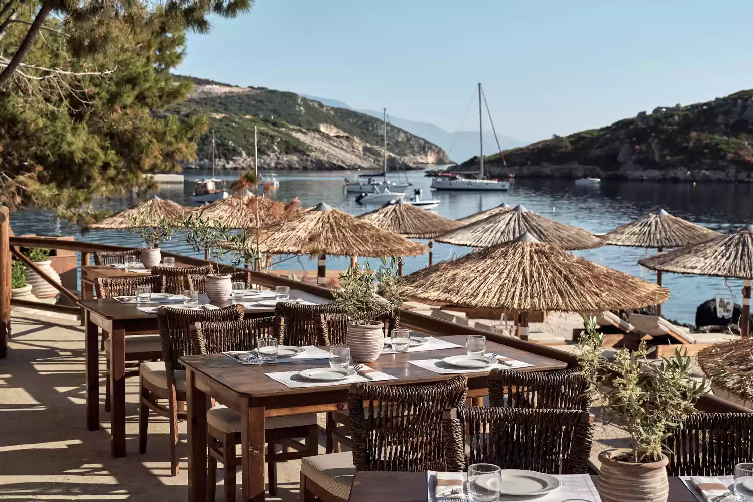 Dining tables set next to the turquoise sea at a local Zakynthos restaurant.