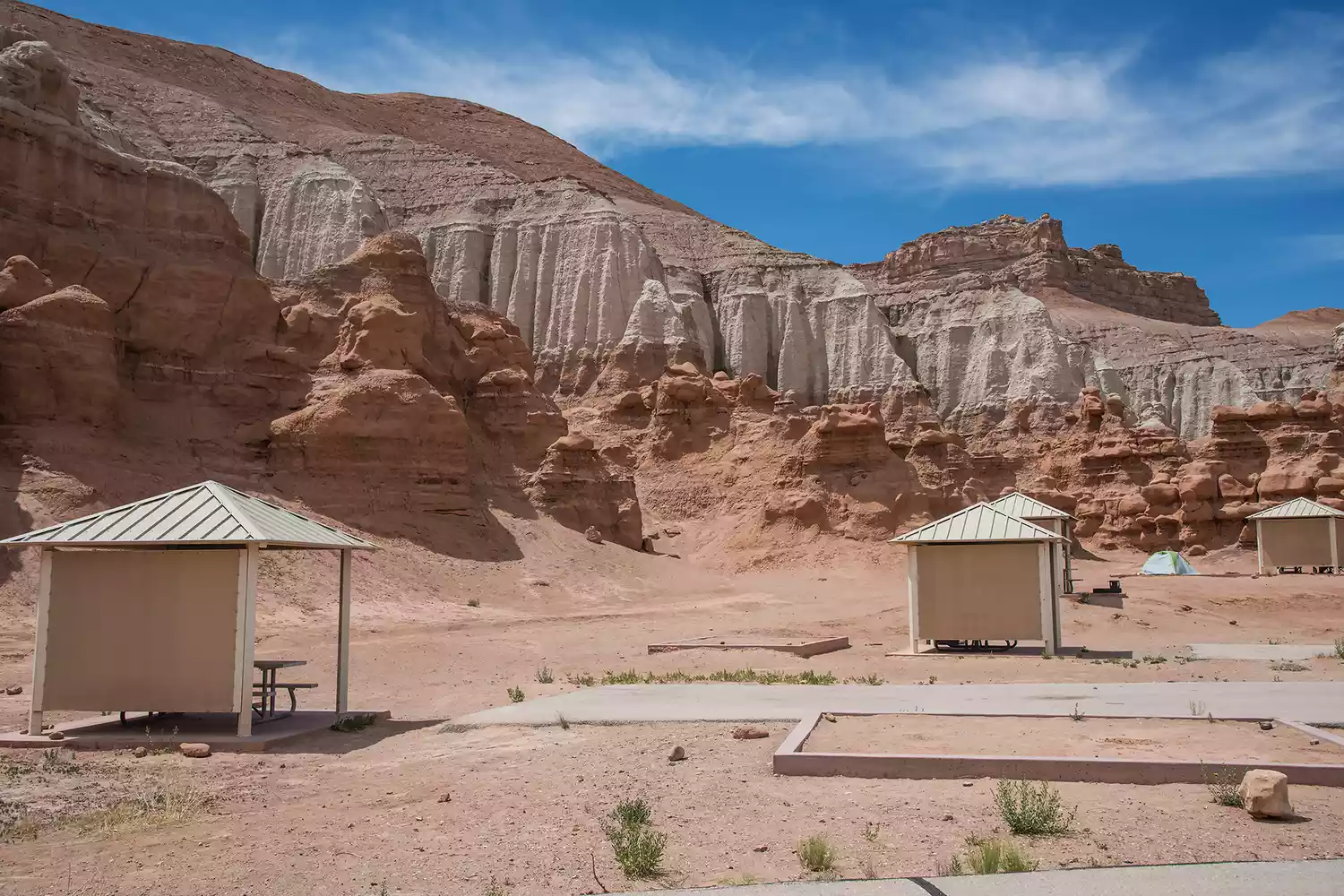 Camping tents set up amidst the unique hoodoo rock formations of Goblin Valley State Park in Utah.